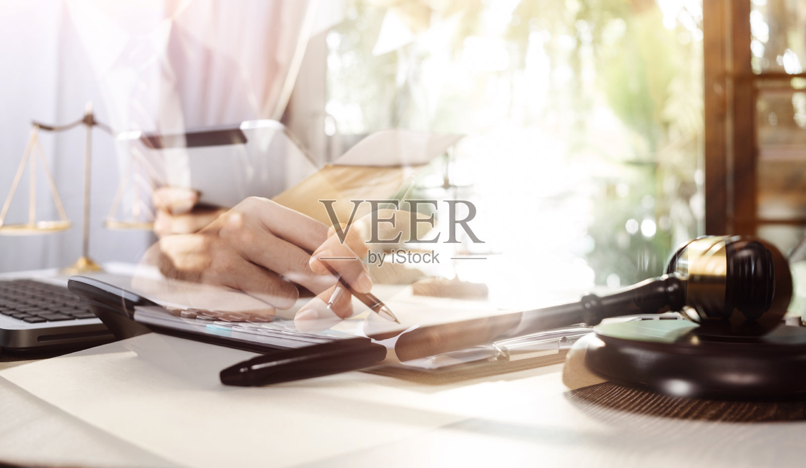 商业和律师在办公室的办公桌上用黄铜秤讨论合同文件。法律、法律服务、法律咨询、司法和法律概念画面具有胶片颗粒效应照片摄影图片