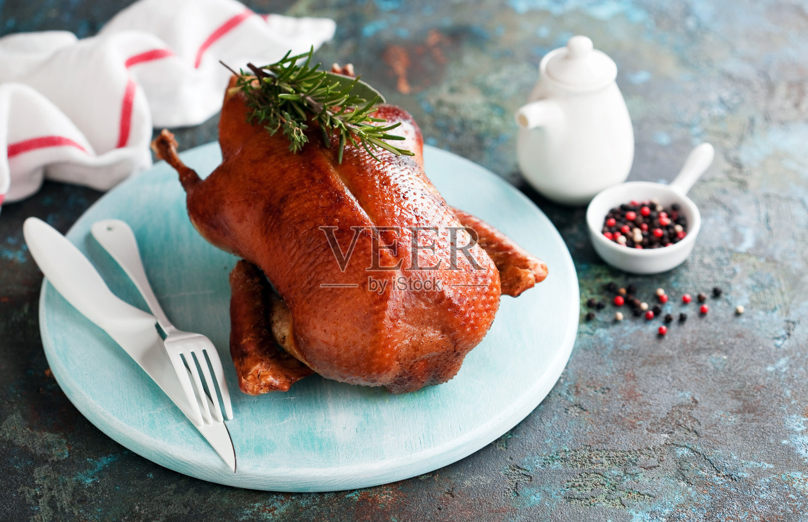 整只金黄酥脆的烤鸭放在木盘里照片摄影图片