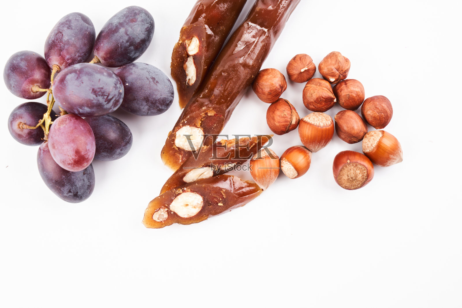 用葡萄汁和榛子做成的格鲁吉亚民族甜点，白色背景上的独立构图，复制空间照片摄影图片