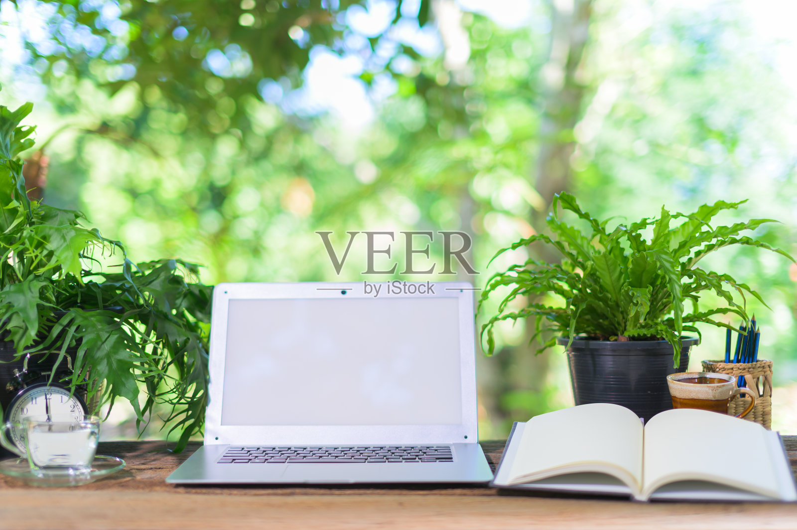 笔记本电脑和固定设备在书桌上，自然景色照片摄影图片