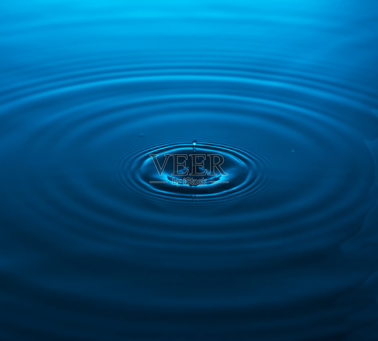 浪花从一个落点落进蓝色的水里。照片摄影图片