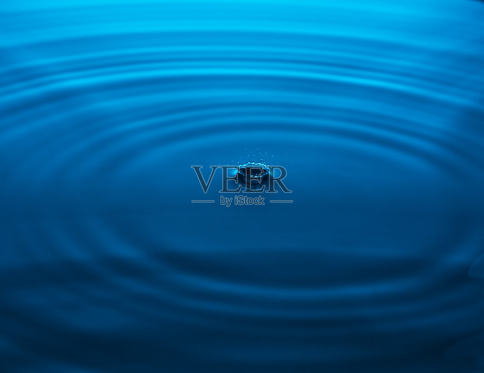 浪花从一个落点落进蓝色的水里。照片摄影图片