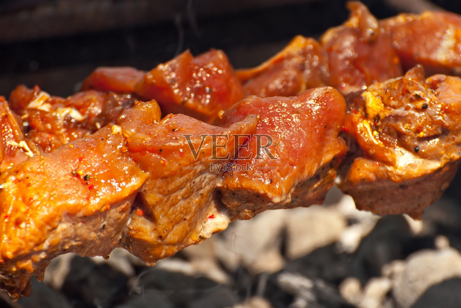 把肉切成片放在烤架上。节日烧烤。奶酪和烤小牛肉串。照片摄影图片