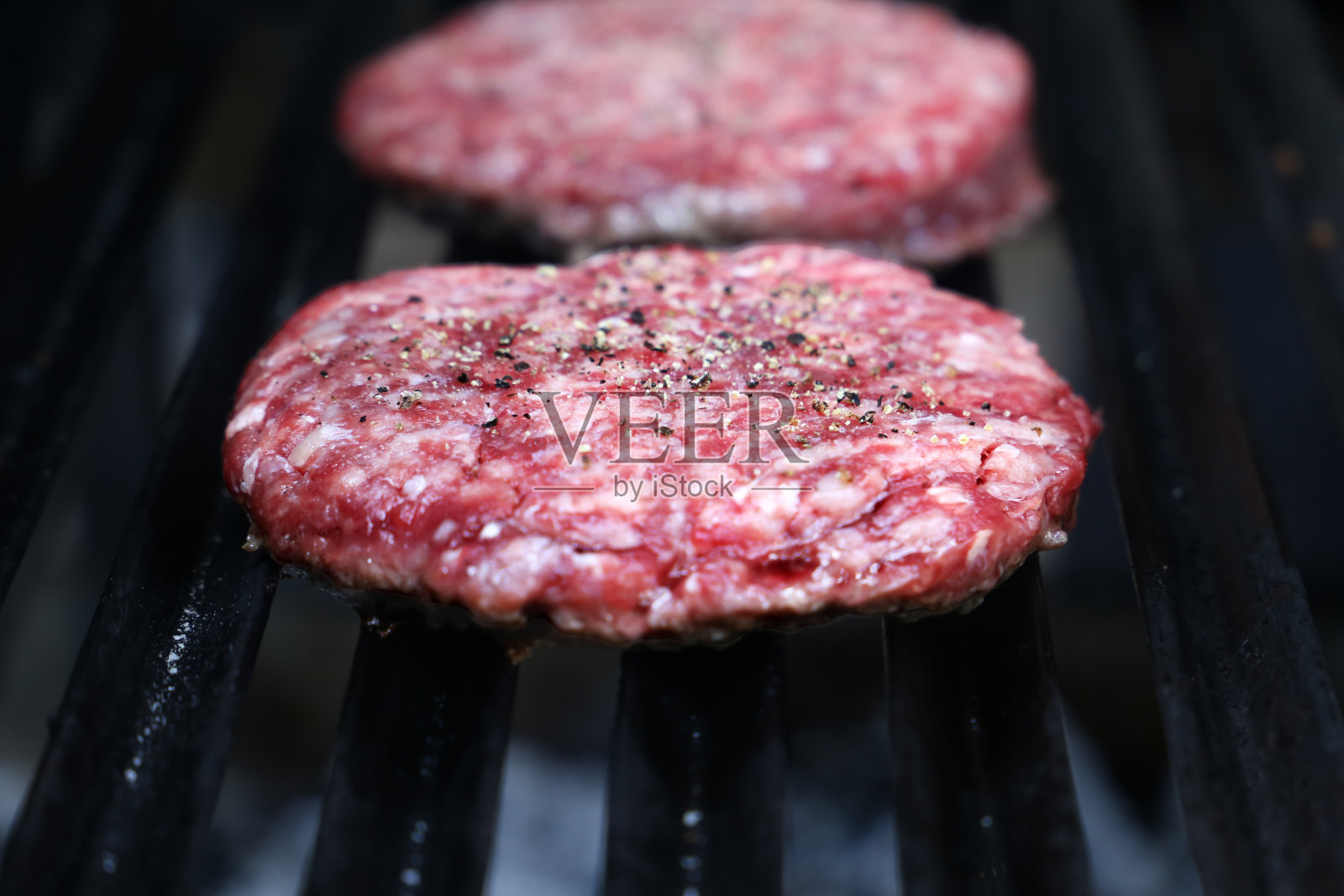 在巴西烤肉架上的生汉堡照片摄影图片