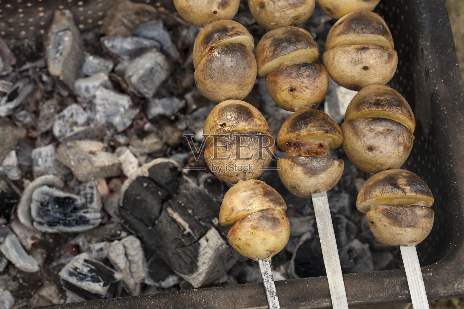 烤土豆，烤土豆。烤土豆串在烤肉串上。街道节日食品照片摄影图片