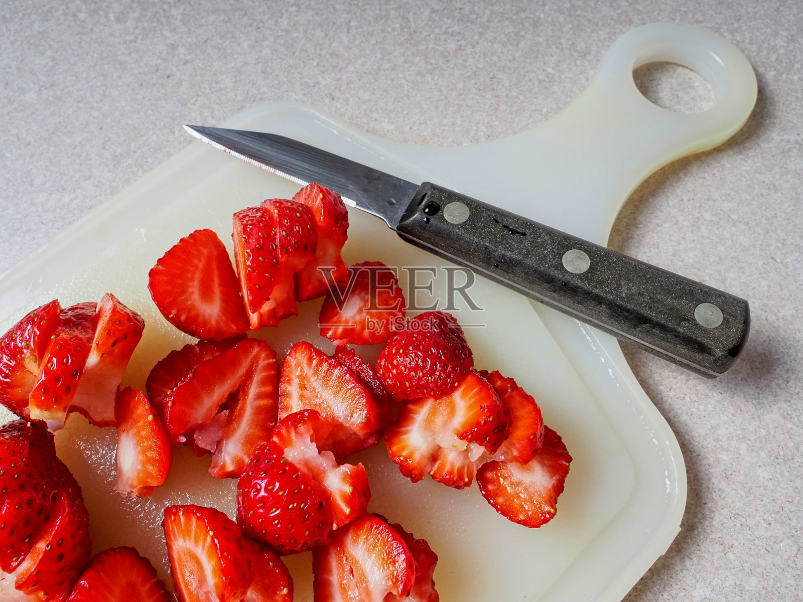将新鲜草莓切片放在砧板上准备加入食谱照片摄影图片