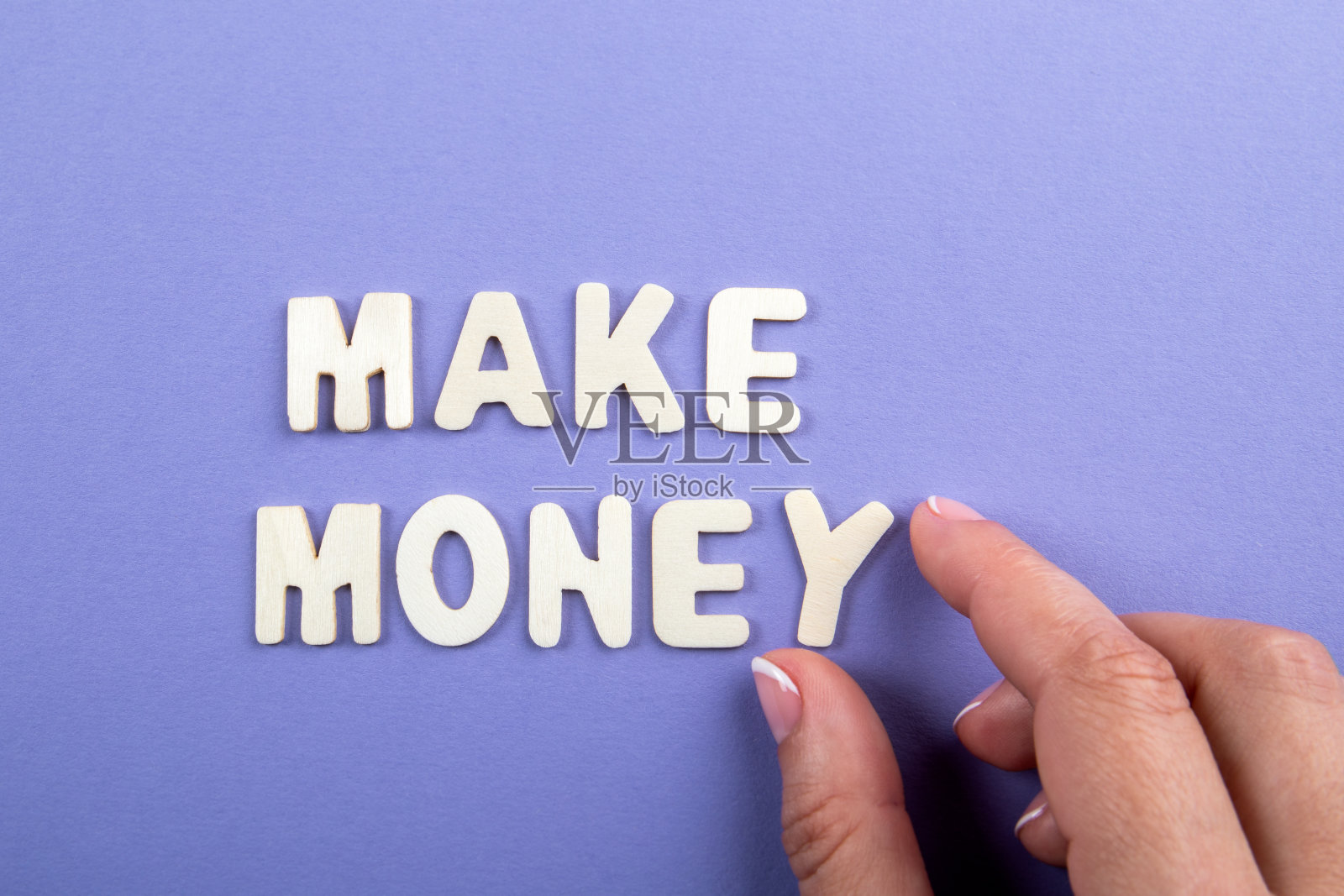 赚钱。紫色背景上的白色木制字母照片摄影图片