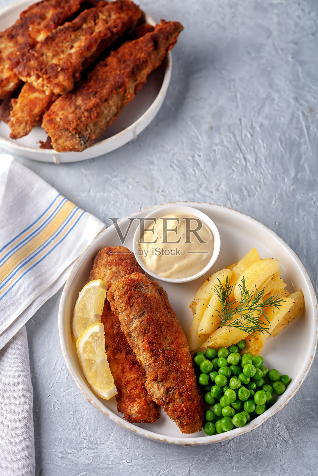 炸鱼配炸土豆，青豆和柠檬照片摄影图片