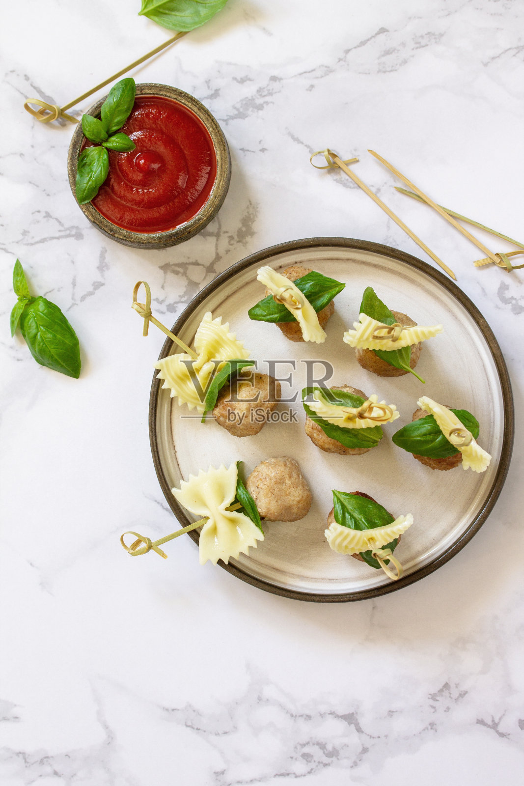 生日或浪漫的晚餐。意大利面以开胃菜、肉丸的形式烹饪，配以番茄酱，放在大理石台面上。俯视图平铺。副本的空间。照片摄影图片