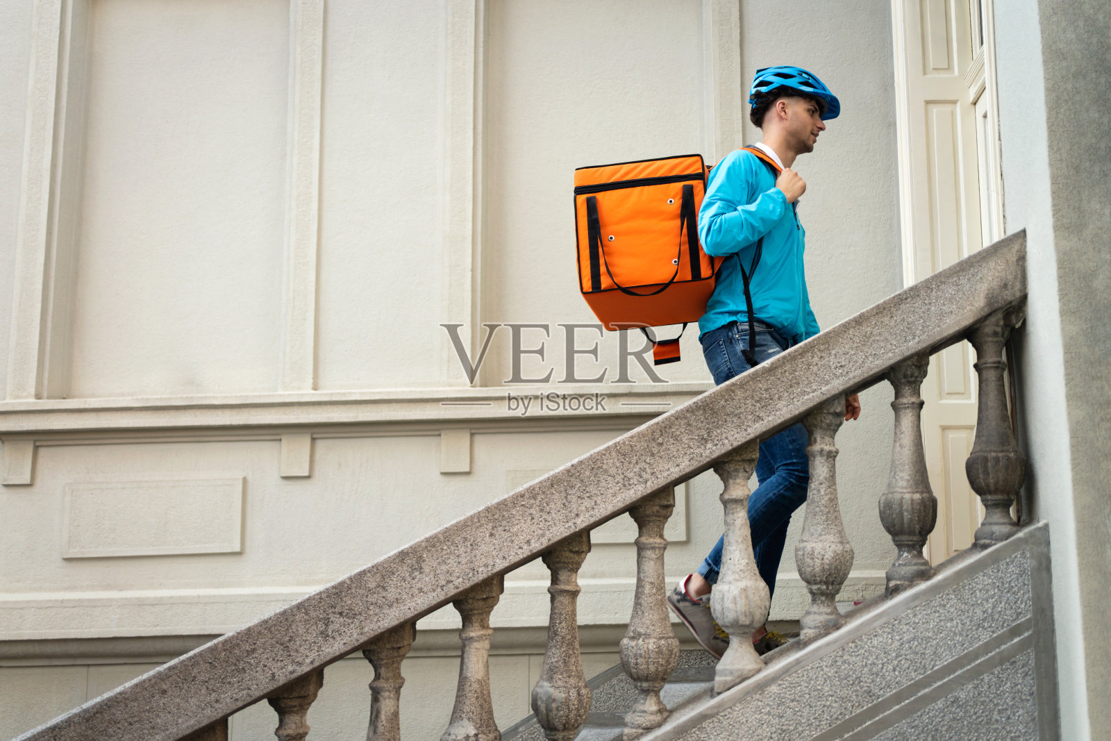 一个拿着红包的快递员进入了一栋住宅楼照片摄影图片