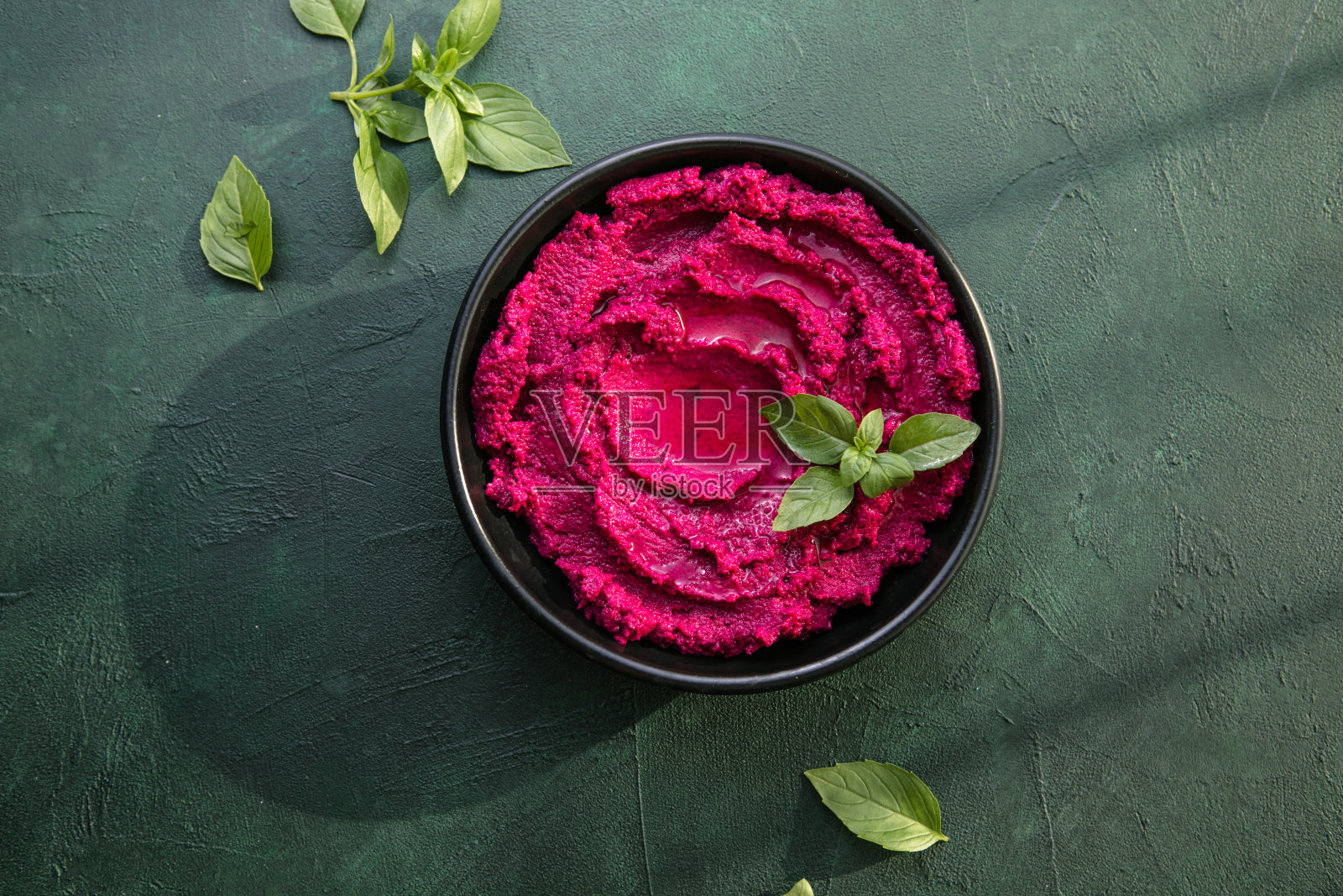 腐殖质碗。红甜菜根鹰嘴豆泥配新鲜蔬菜，桌上放橄榄油照片摄影图片