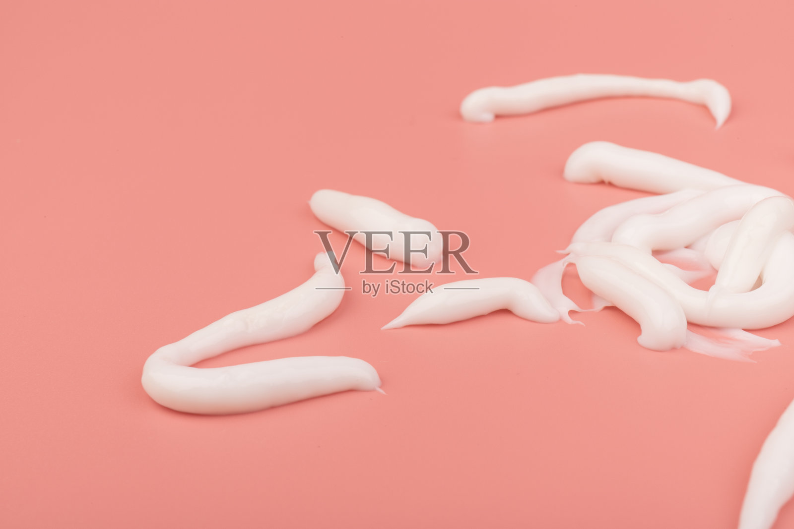 白色化妆品涂抹孤立在粉红色的背景。护肤产品质地细腻。照片摄影图片