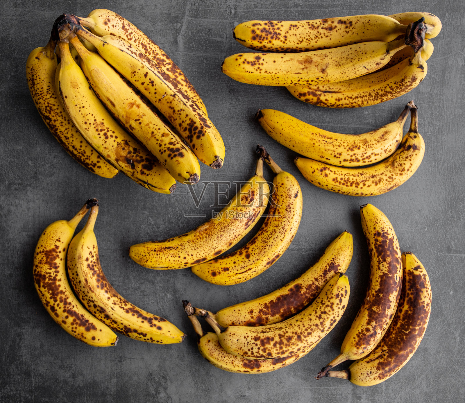 黑色混凝土背景下的成熟香蕉。一堆可以吃的有机香蕉。照片摄影图片