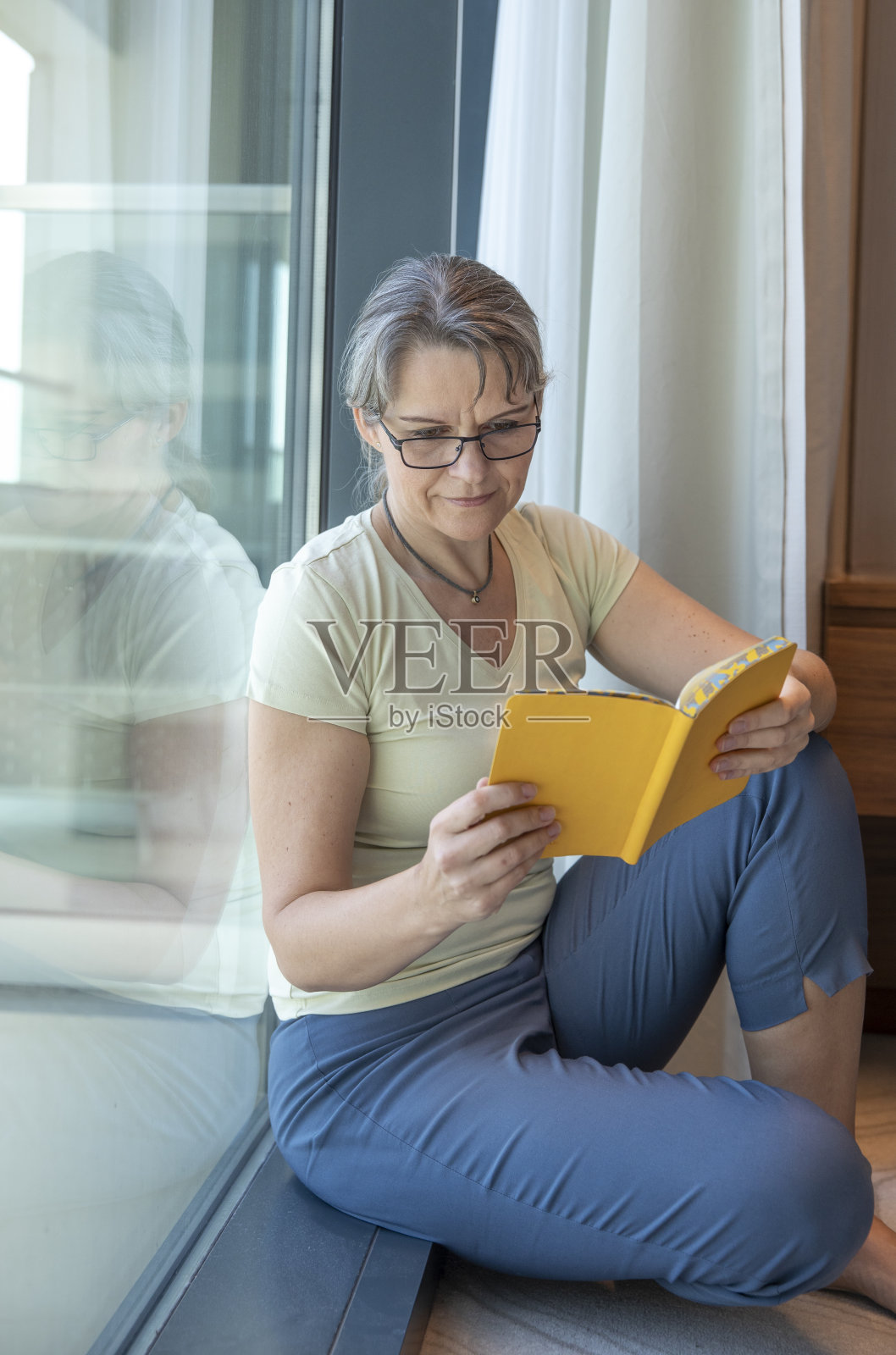 阅读书籍的中年妇女照片摄影图片