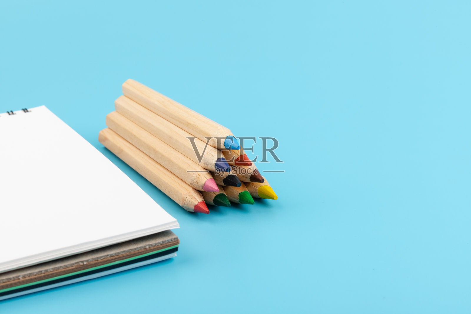 蓝色背景上的空白纸和一支彩色铅笔照片摄影图片