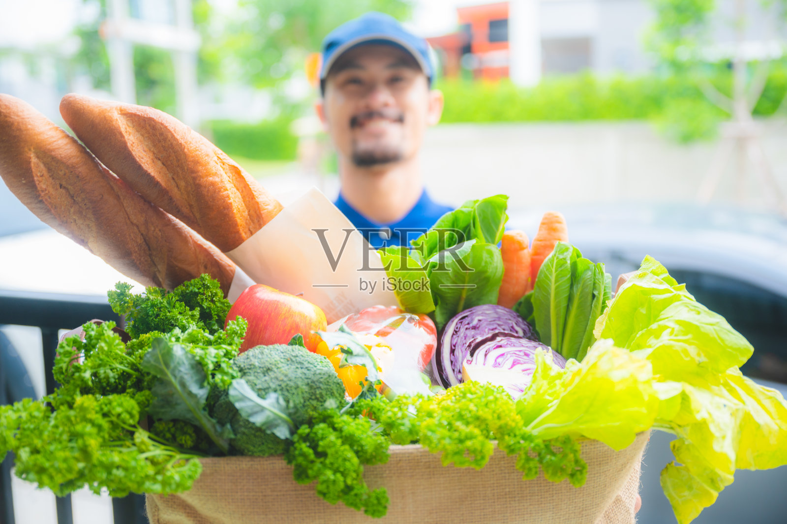 一个面带微笑的好男人，快速将食品杂货送到顾客家中，在检疫期间网购新冠肺炎，食品装在环保纸袋里，用心工作照片摄影图片