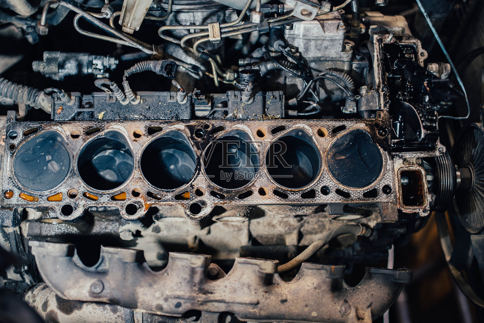 修理一台直列式柴油机的发动机缸盖，打开燃烧室。照片摄影图片