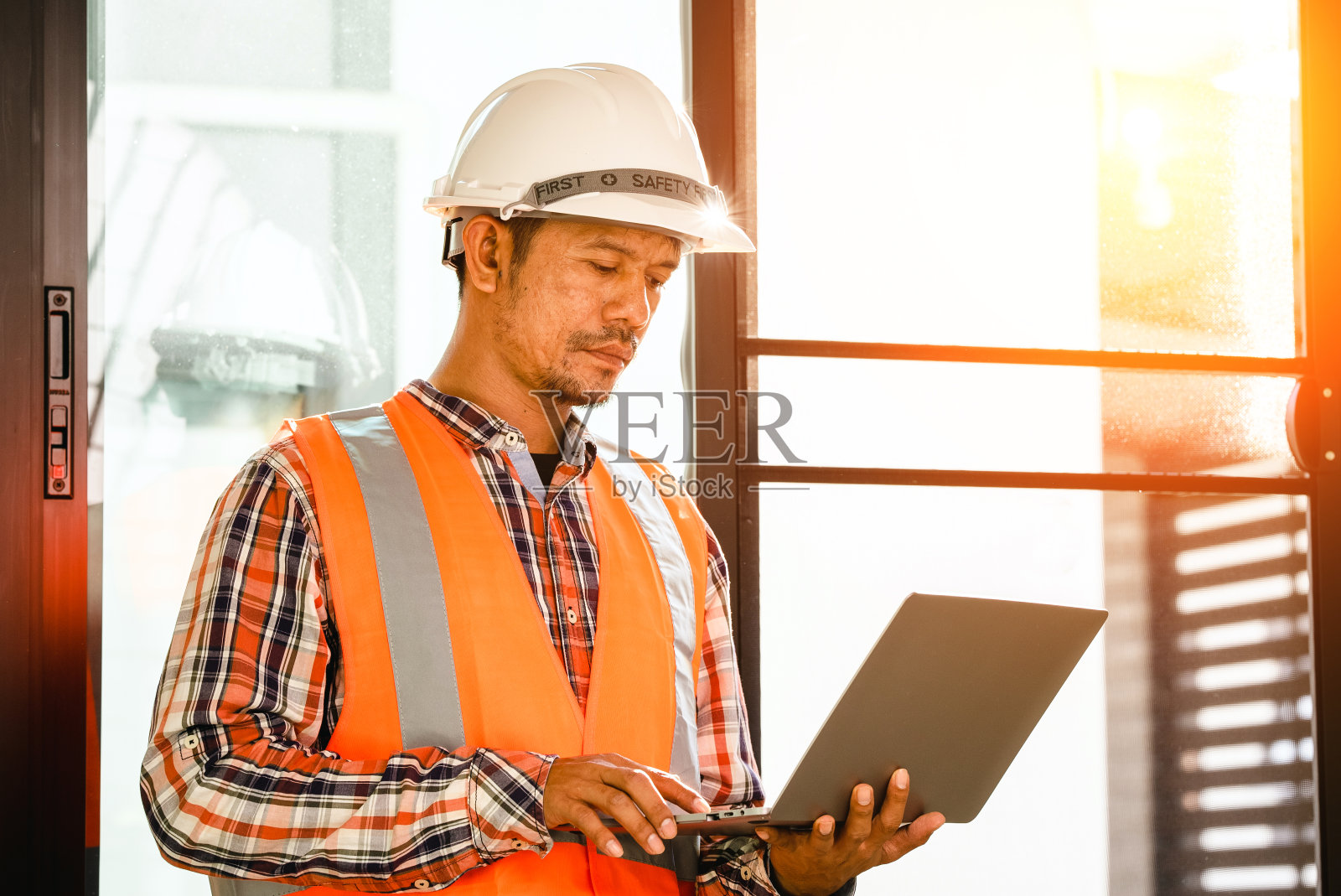 男工程师工作工具工程师办公桌，戴着头盔照片摄影图片