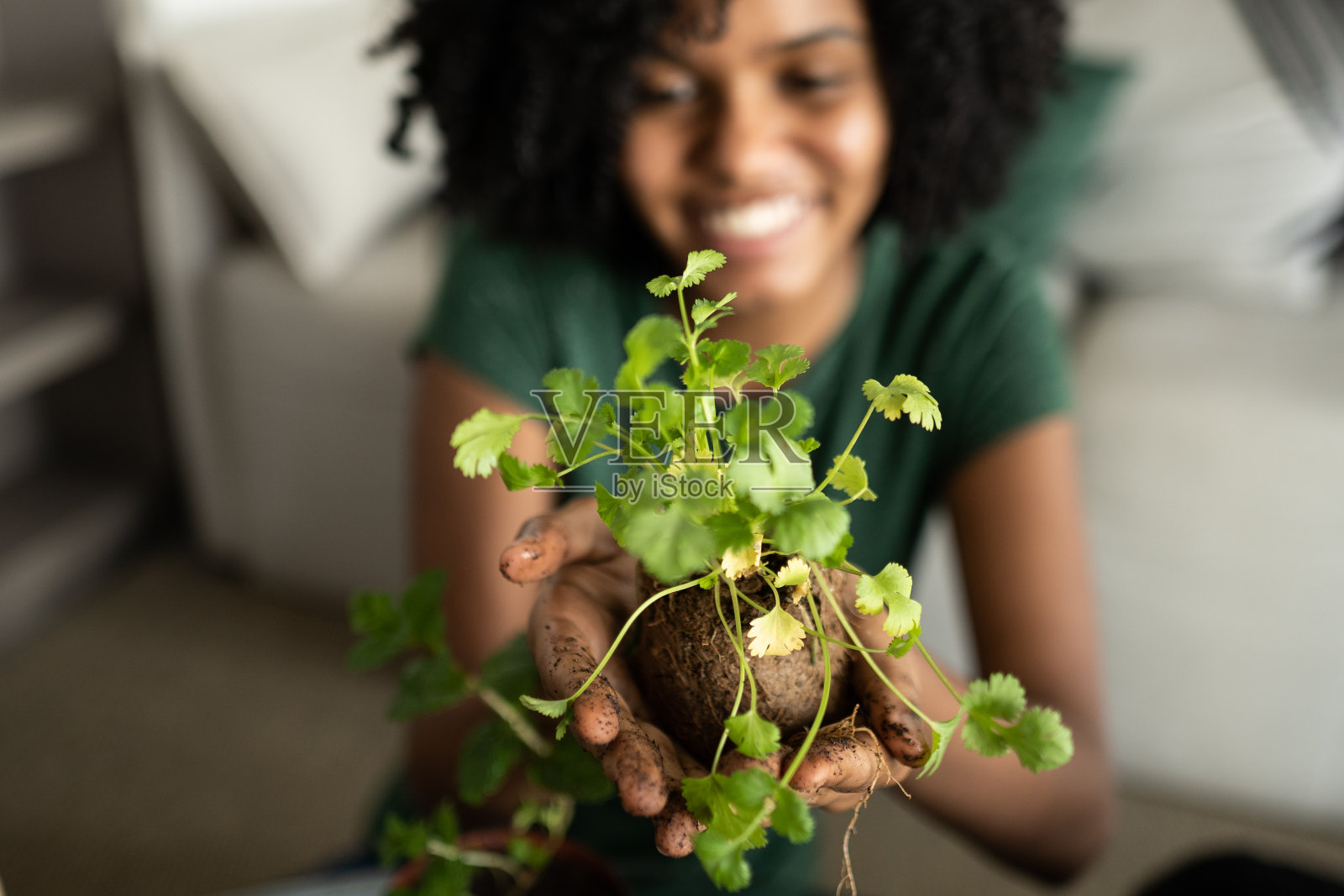 骄傲的女孩在她的房子里展示植物照片摄影图片
