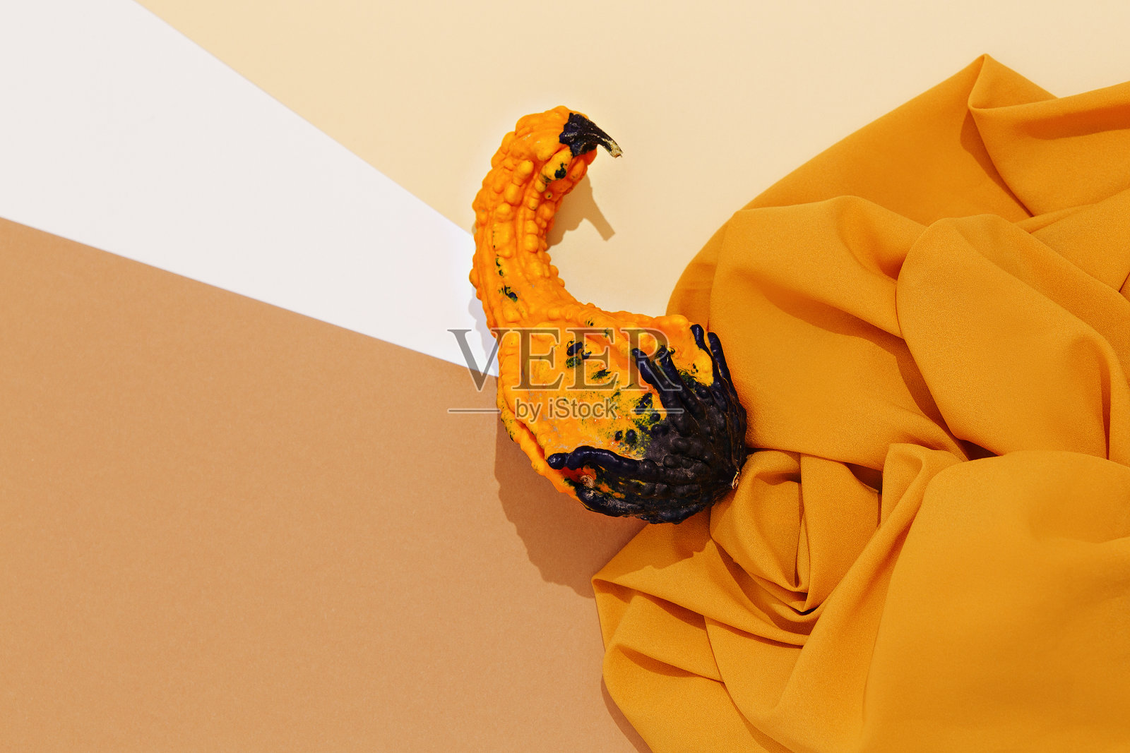 秋冬背景秋冬南瓜装饰和黄色丝绸织物。时髦的棕色、黄色、米黄色色调。季节性的旗帜照片摄影图片