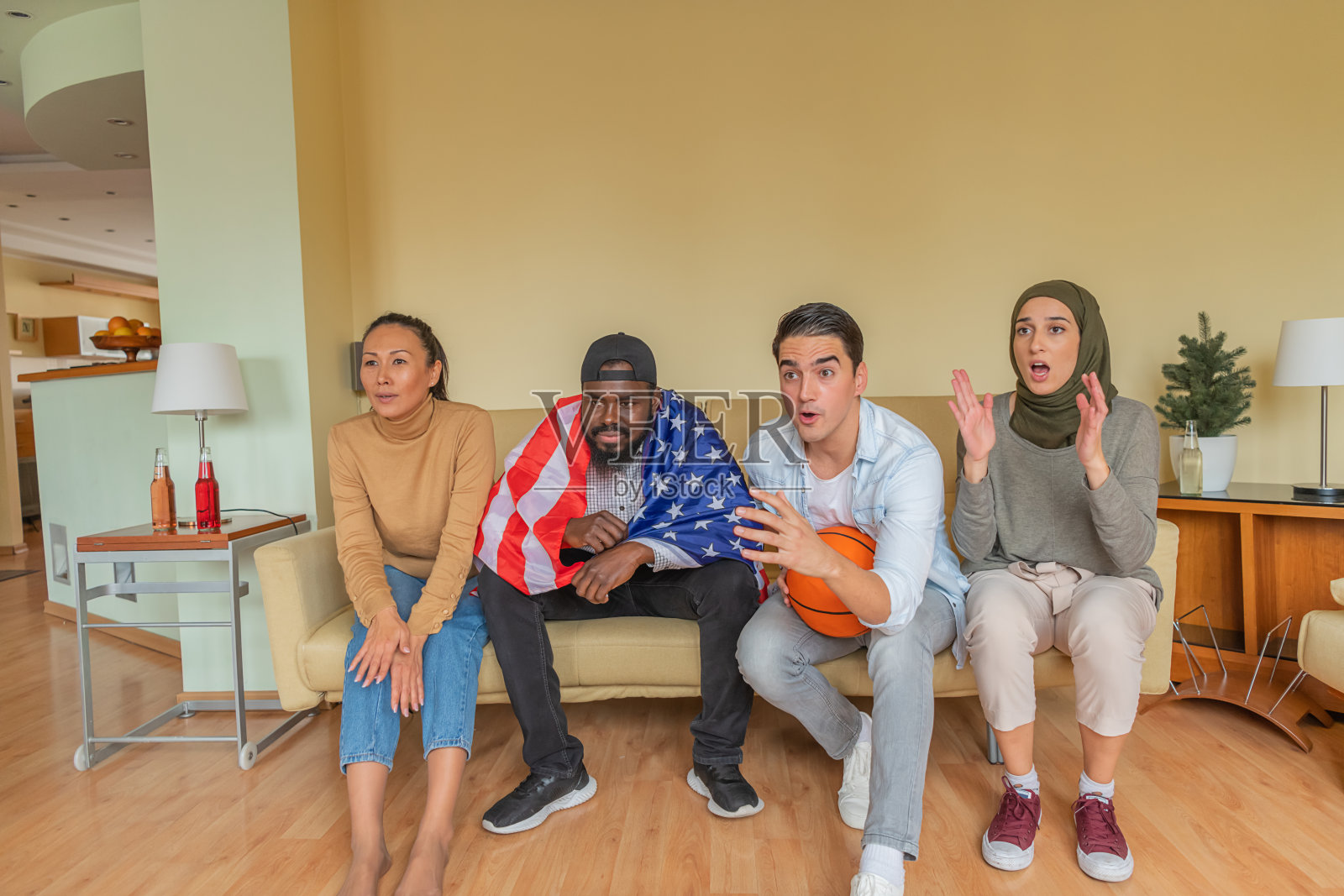 来自美国的快乐多元文化朋友们在家中观看篮球比赛。照片摄影图片