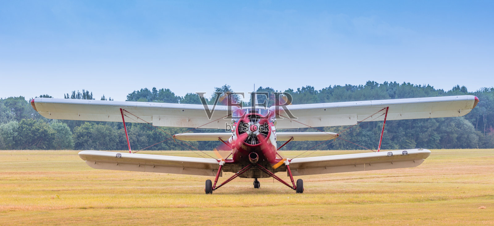 一架老式双翼飞机，在机场着陆后引擎还在运转照片摄影图片