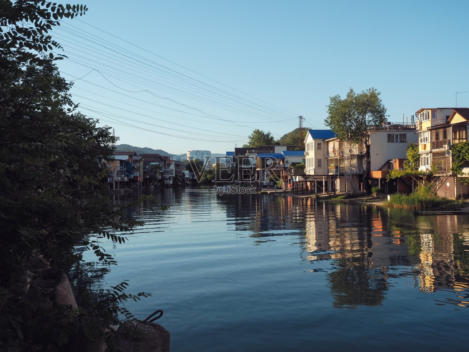 一条平静的河流在私人住宅建筑之间流动照片摄影图片