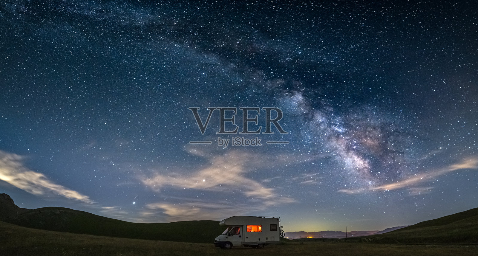 意大利阿布鲁佐坎波Imperatore高地的全景夜空。银河系的弧线和星星照亮了露营车。在独特的山地景观中自由露营。照片摄影图片