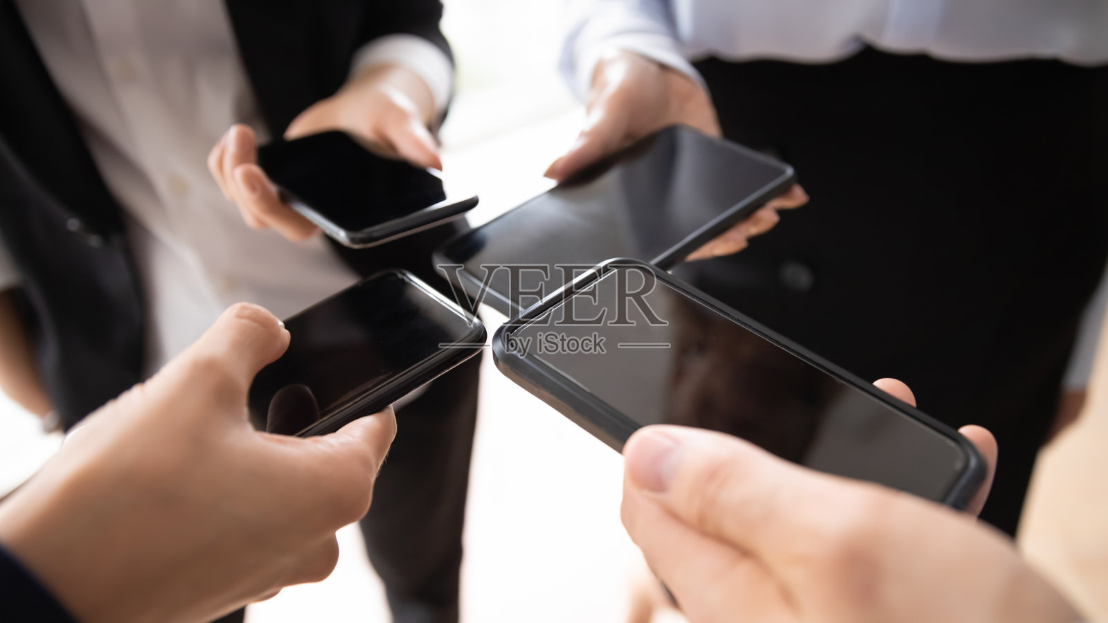 商业团体围成一圈，拿着类似的手机照片摄影图片