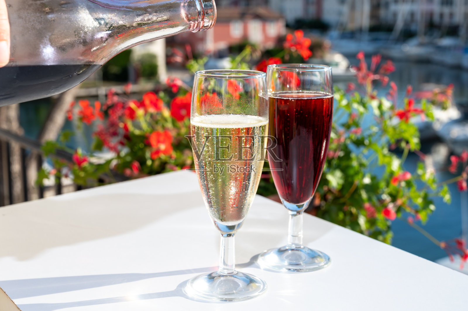 夏日派对与基尔皇家鸡尾酒，倒法国brut香槟起泡酒和冷奶油黑醋栗在游艇港口附近的圣特罗佩，法国里维埃拉度假，法国照片摄影图片