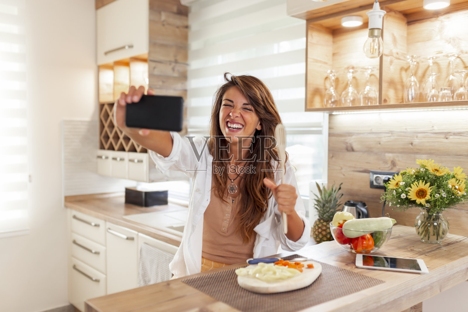 女人一边做饭一边自拍照片摄影图片