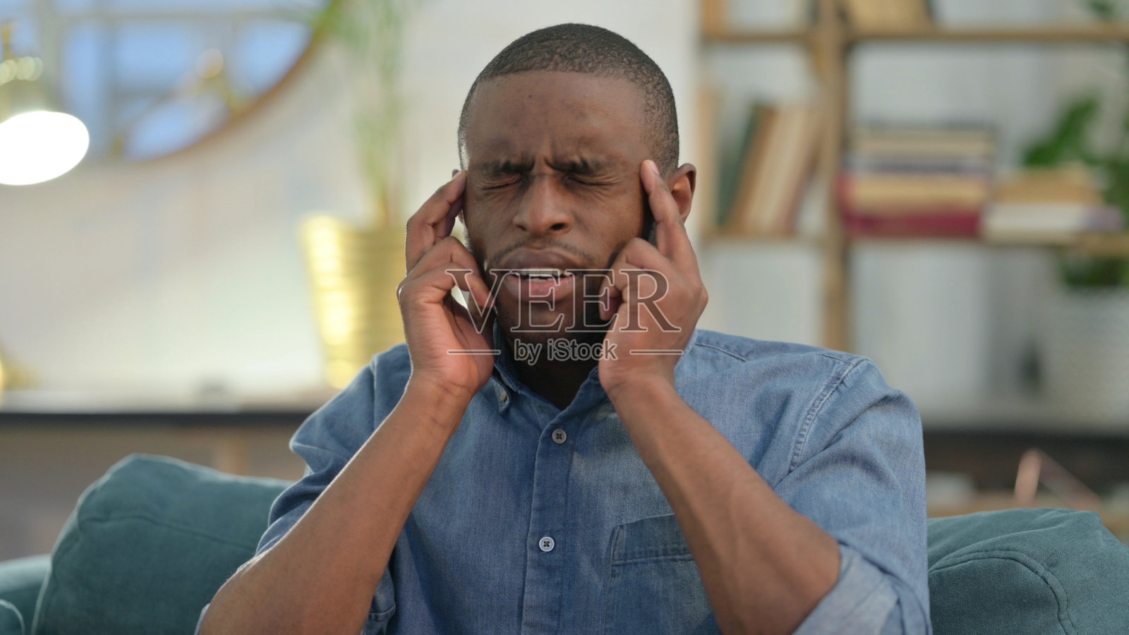 在家头痛的年轻非洲男子照片摄影图片