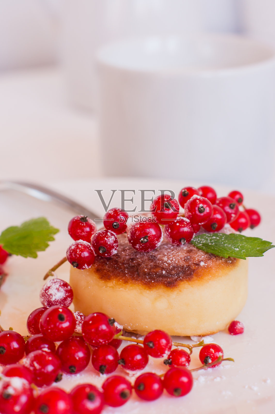 红醋栗盘上的甜农家奶酪煎饼。俄罗斯干酪，乳清干酪或凝乳馅饼。照片摄影图片