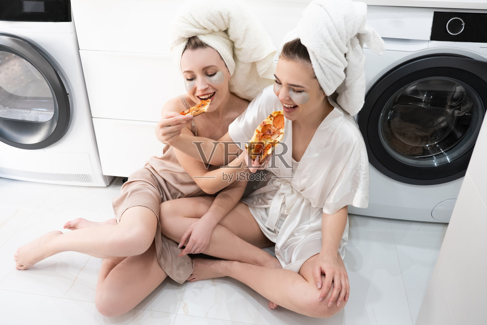 年轻的欧洲女人在浴室里吃披萨照片摄影图片