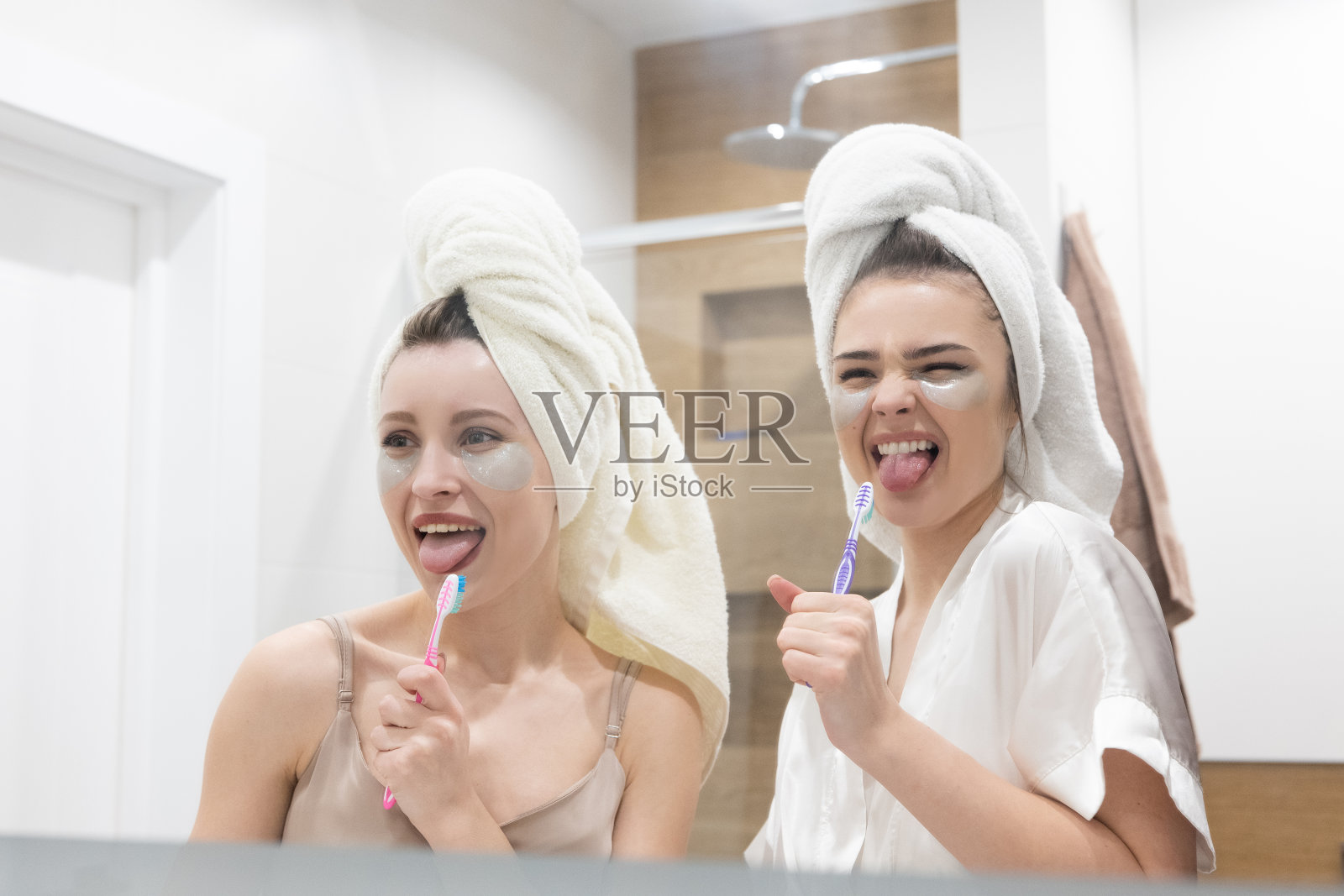 女孩们对着牙刷唱歌，就像在麦克风里一样照片摄影图片