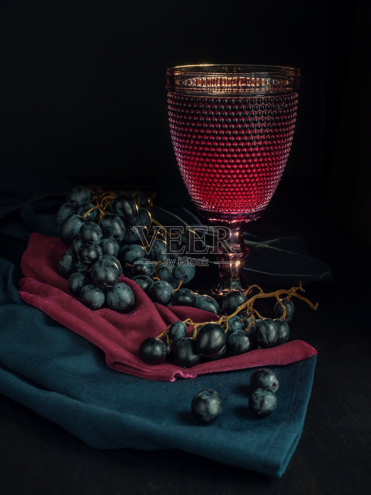 黑色背景下的红酒和葡萄。照片摄影图片