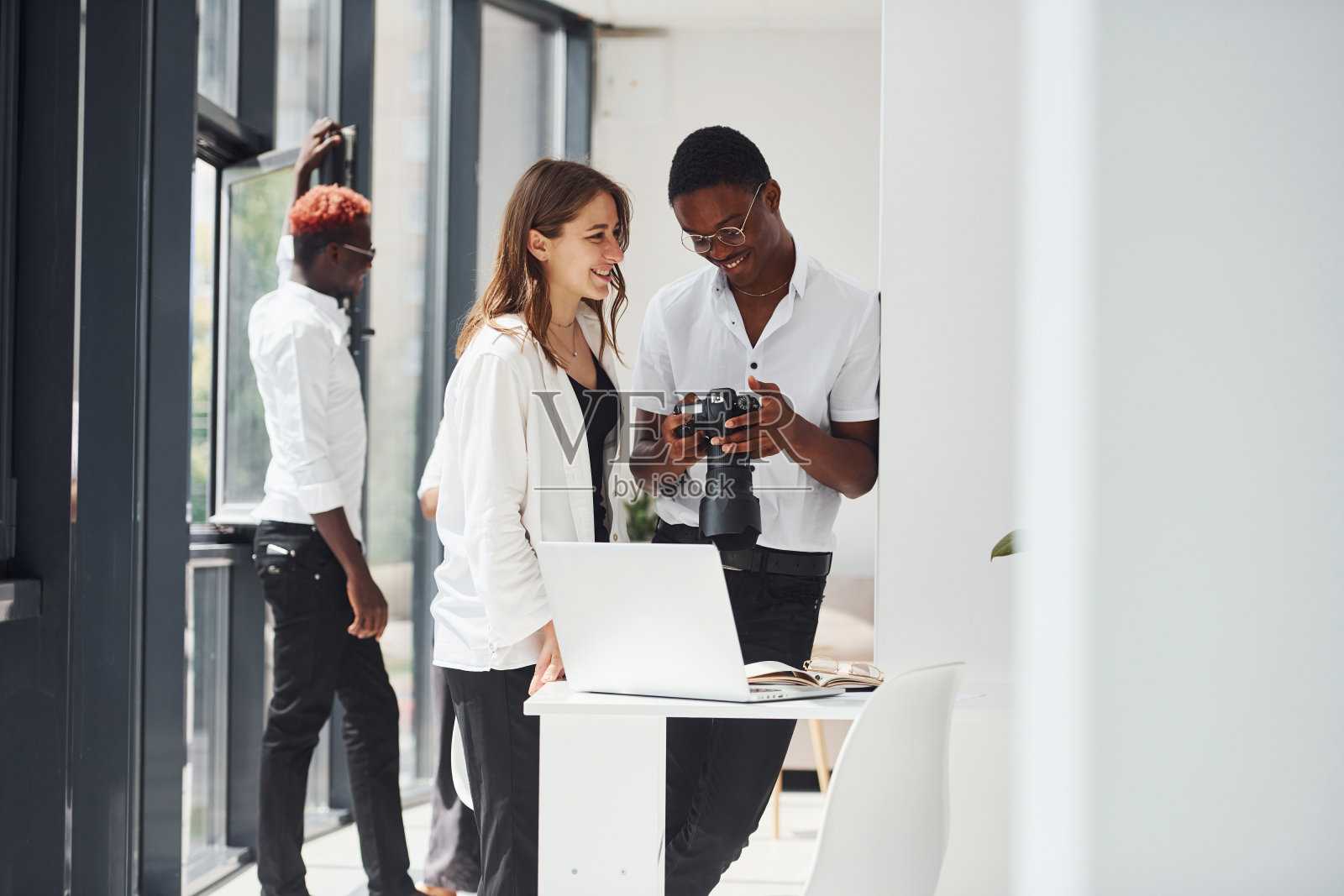 看着摄像机。一群非洲裔美国商人一起在办公室工作照片摄影图片