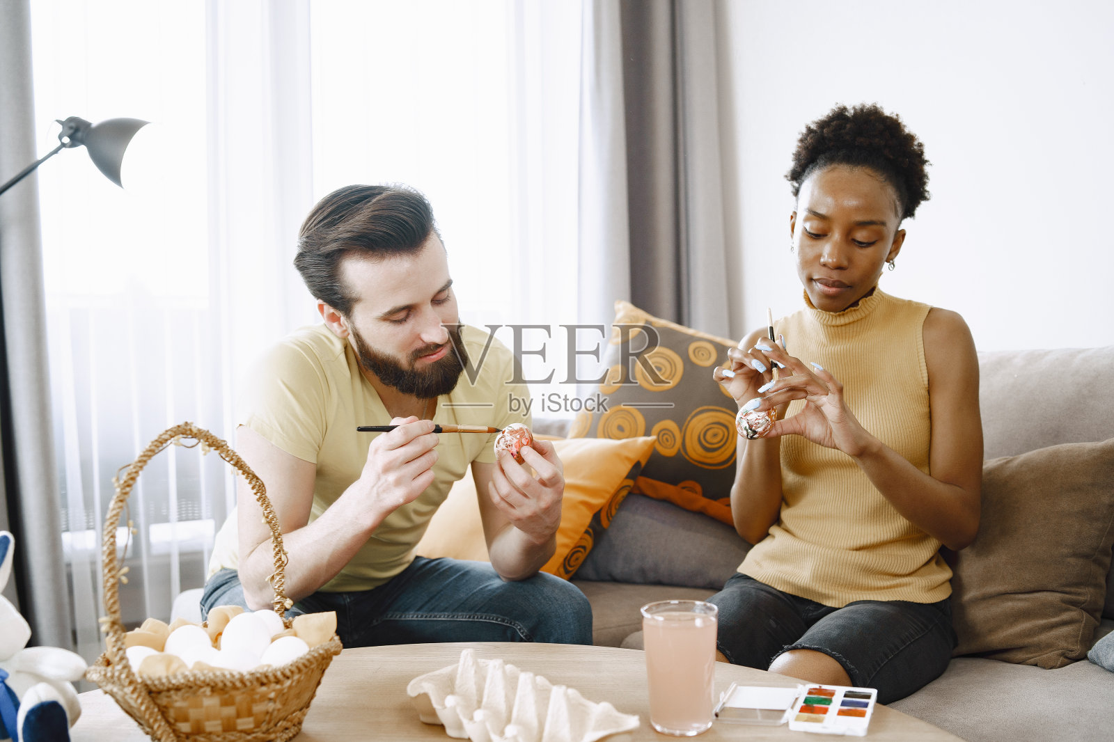 非洲女人和白人男人画复活节彩蛋照片摄影图片