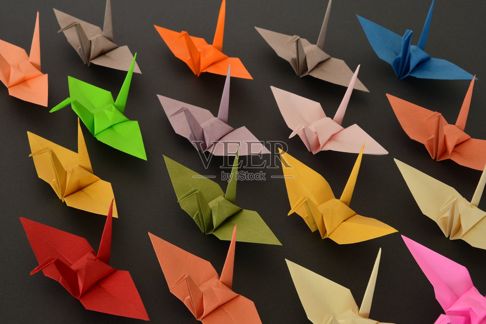 纸鹤在黑色的背景上。照片摄影图片