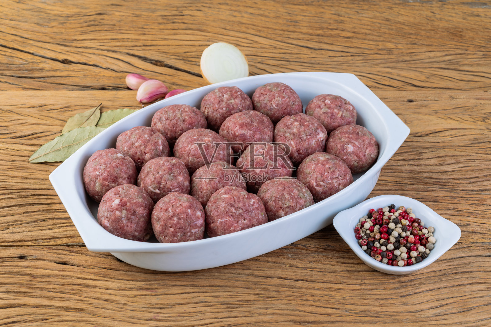 生肉丸放在白色的盘子里，加上调味料照片摄影图片