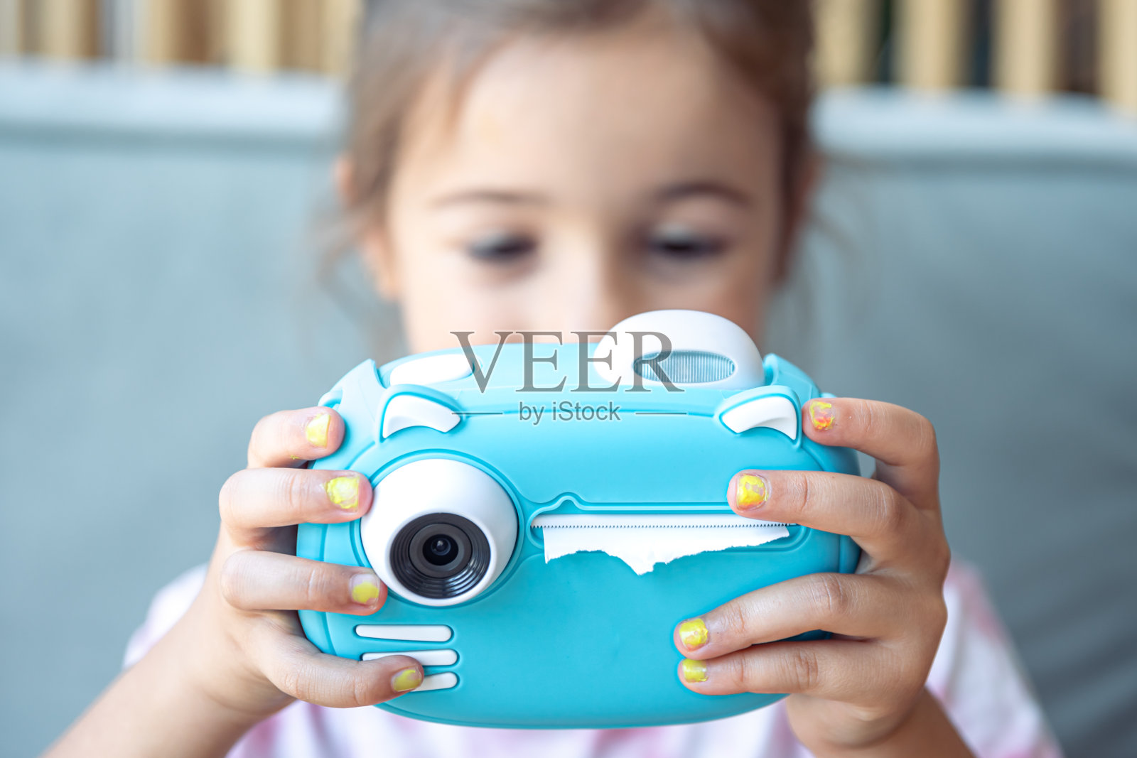 一个小女孩正在用相机拍照，准备瞬间打印照片。照片摄影图片