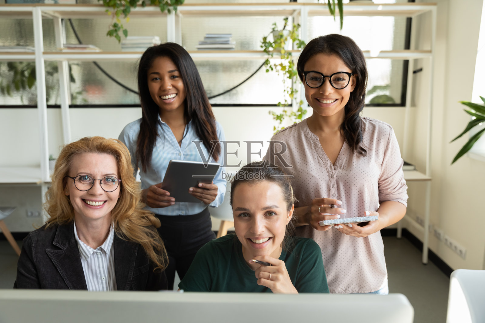 不同的女性商务团队在办公场所使用电脑照片摄影图片