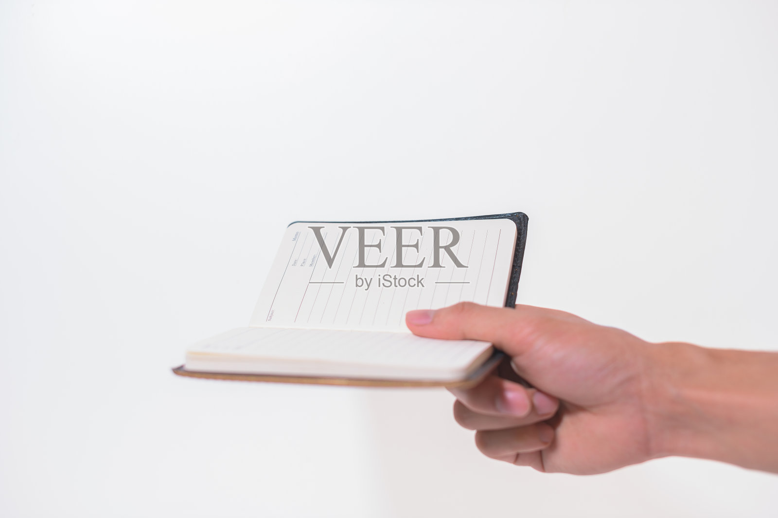 拿着一个白色背景的笔记本照片摄影图片