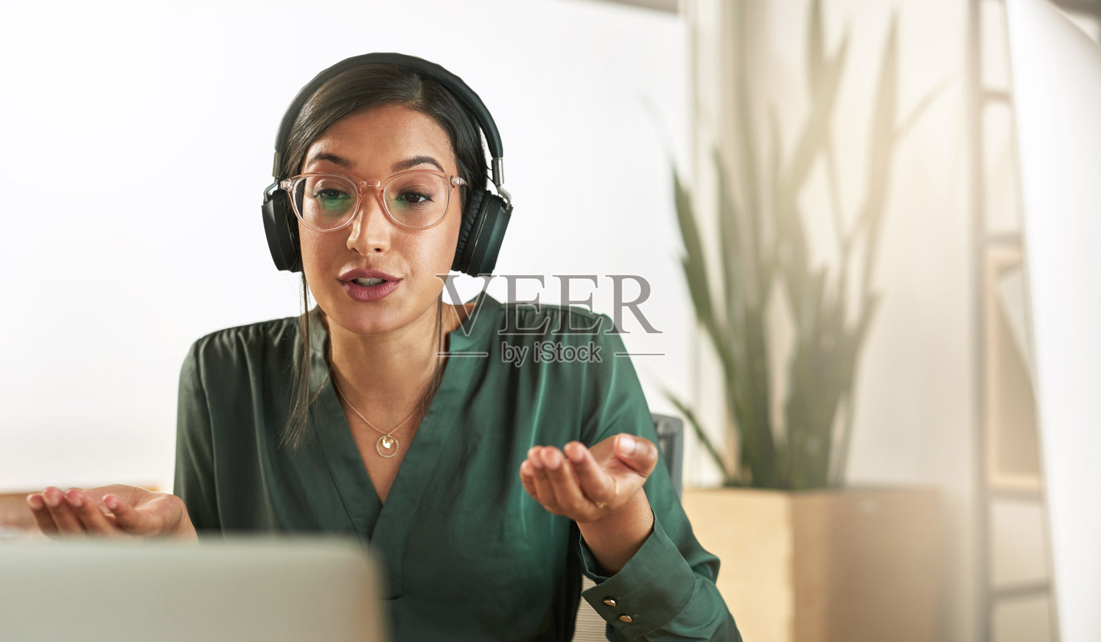 一个年轻的女商人用她的笔记本电脑主持一个视频会议的工作照片摄影图片