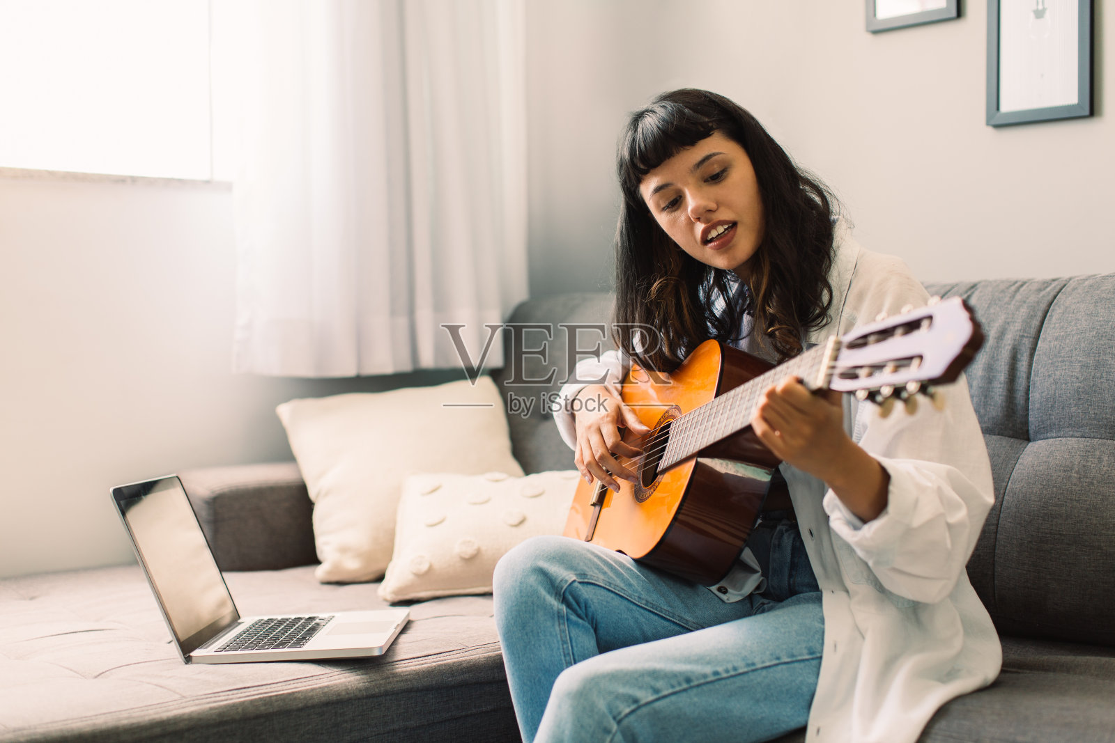 女音乐家在网上教吉他课照片摄影图片