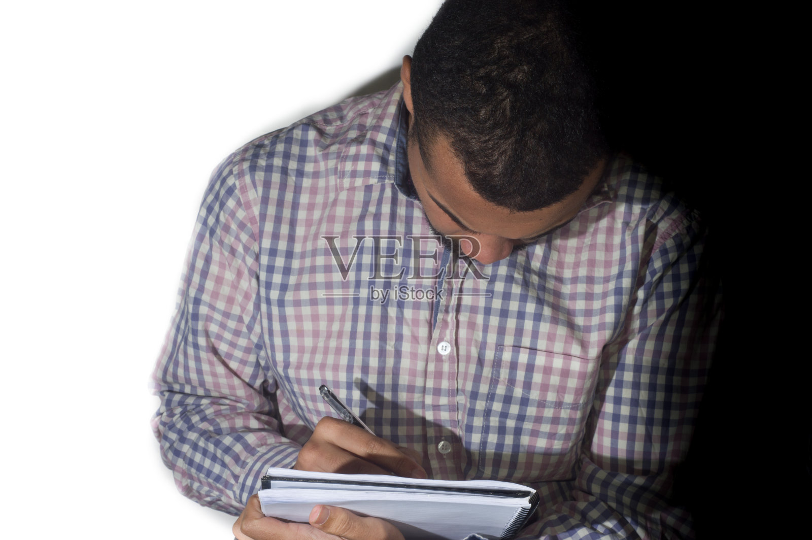 男人在笔记本上写字，抄写空间，半白半黑的背景照片摄影图片