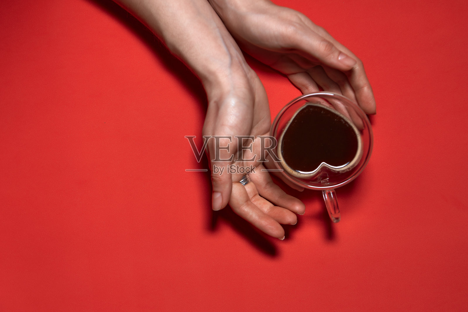 情人节心形背景。女人拿着热的咖啡杯，与心脏形状股票照片。美丽的装饰心形的红色背景，情人节的概念照片摄影图片