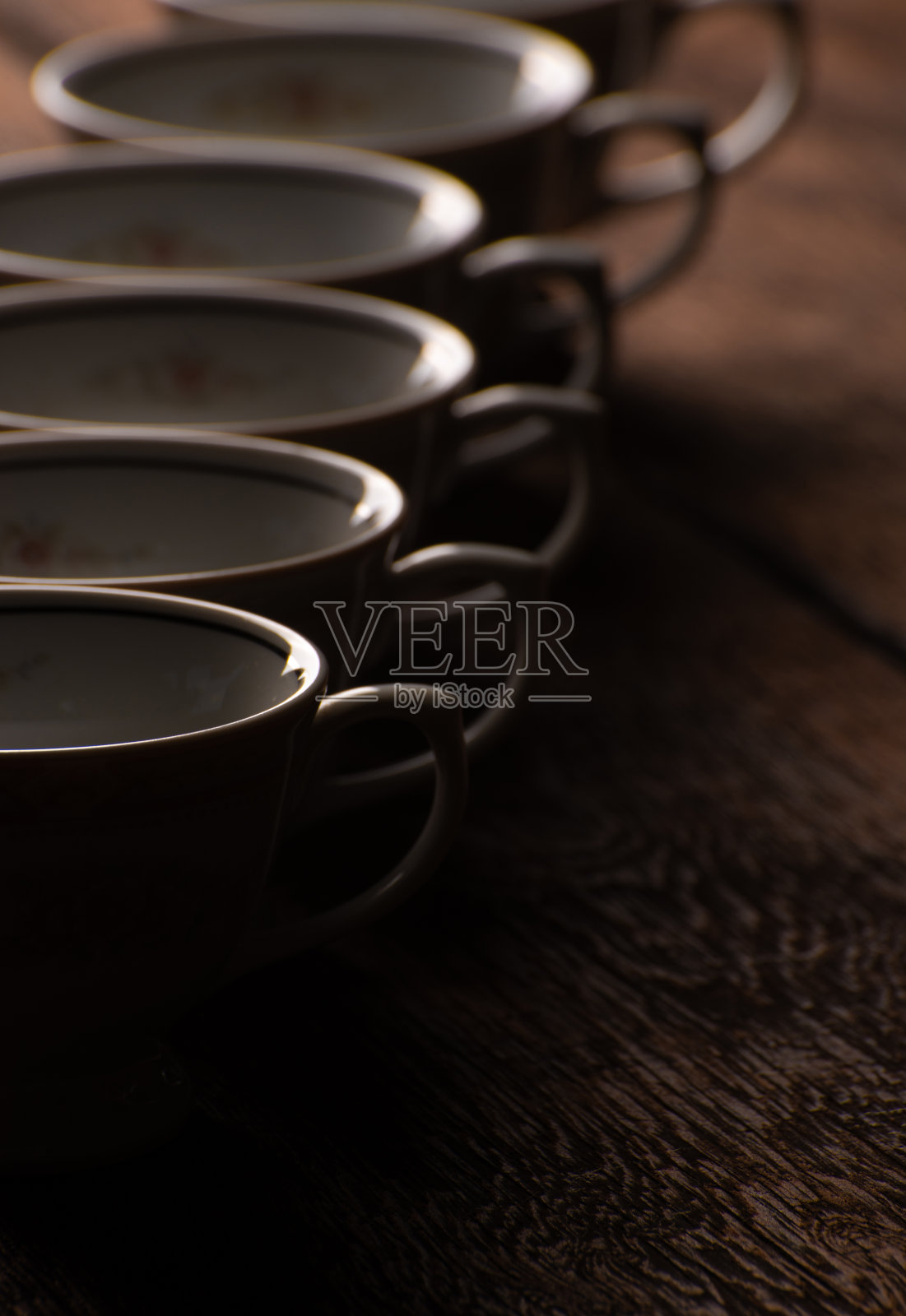 瓷杯，美丽的瓷杯几何排列在质朴的木头上，深色的背景，选择性的焦点。照片摄影图片