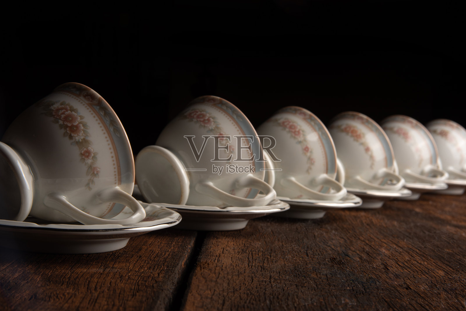 瓷杯，美丽的瓷杯几何排列在质朴的木头上，深色的背景，选择性的焦点。照片摄影图片