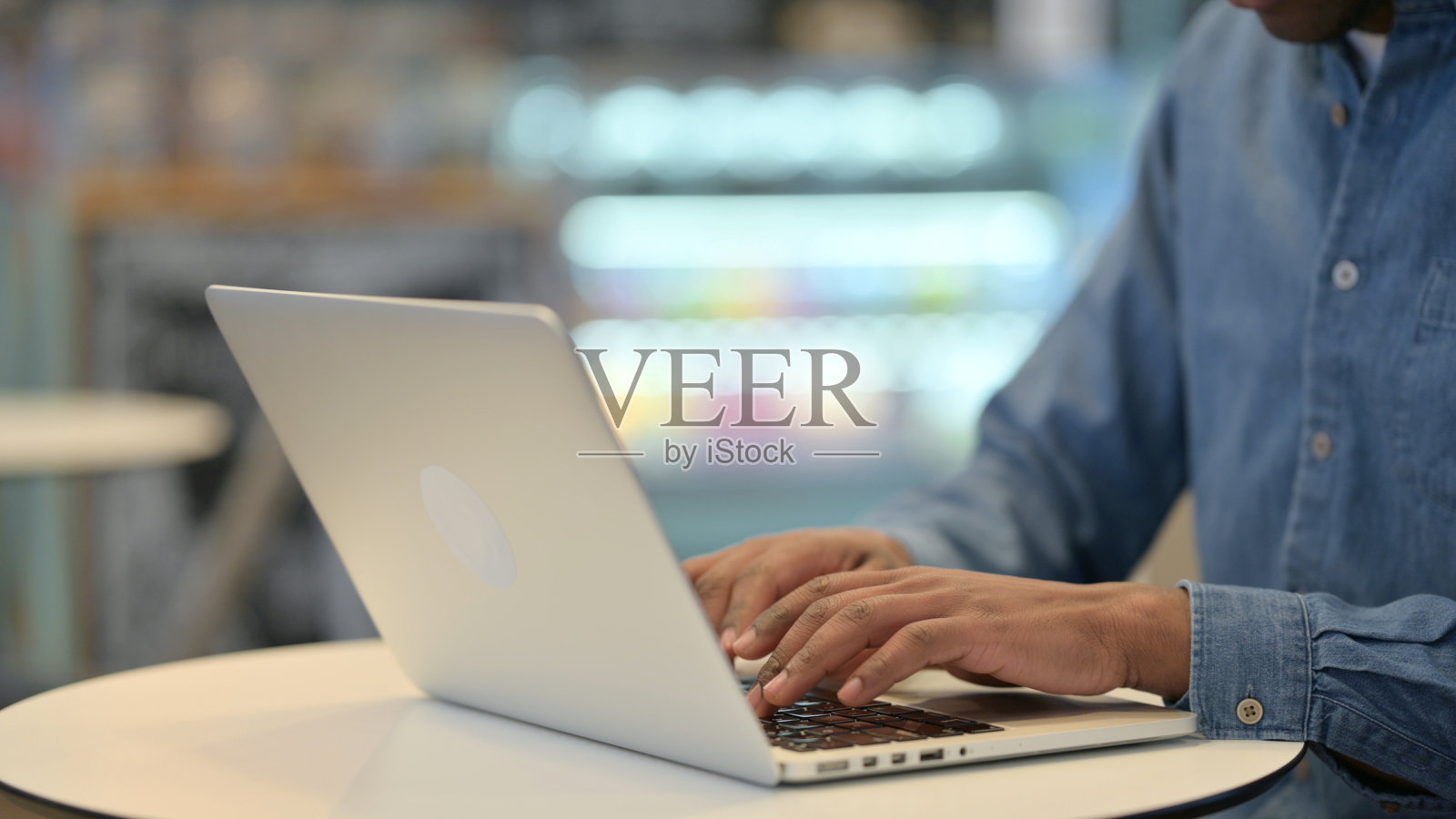 非洲人在笔记本电脑键盘上打字，特写照片摄影图片